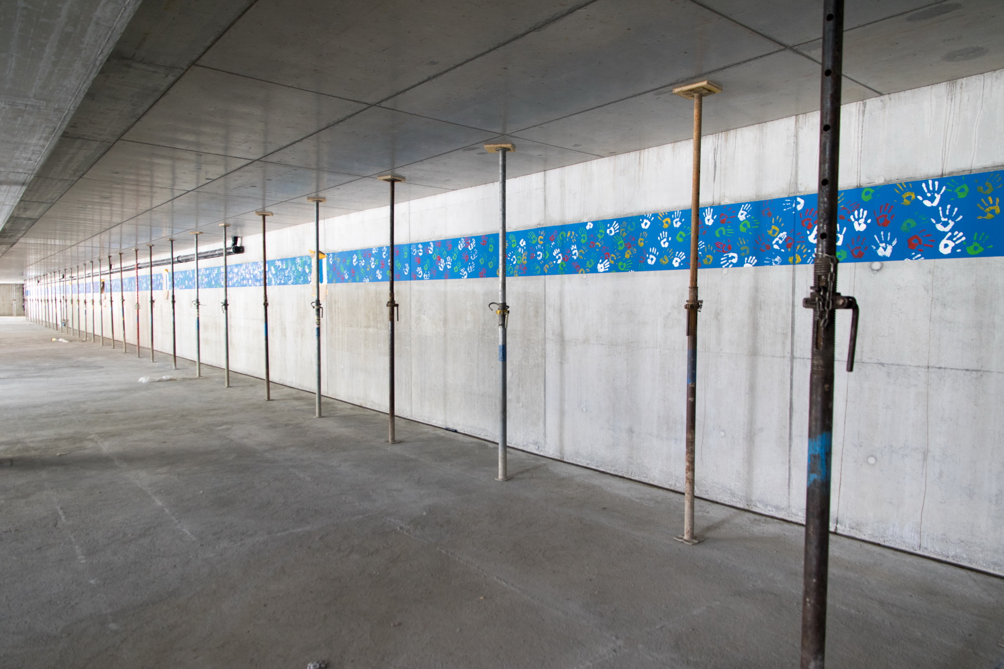 Parking du Louché - La fresque longue de près de 70 mètres a été peinte avant l’achèvement des travaux. Chaque classe a bénéficié de 10 mètres pour y apposer les empreintes.
